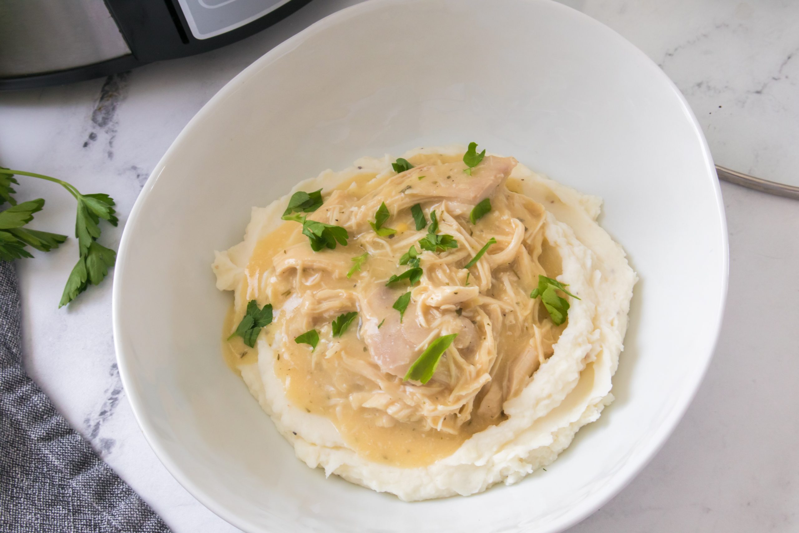 chicken and gravy in a crock pot recipe in a white bowl