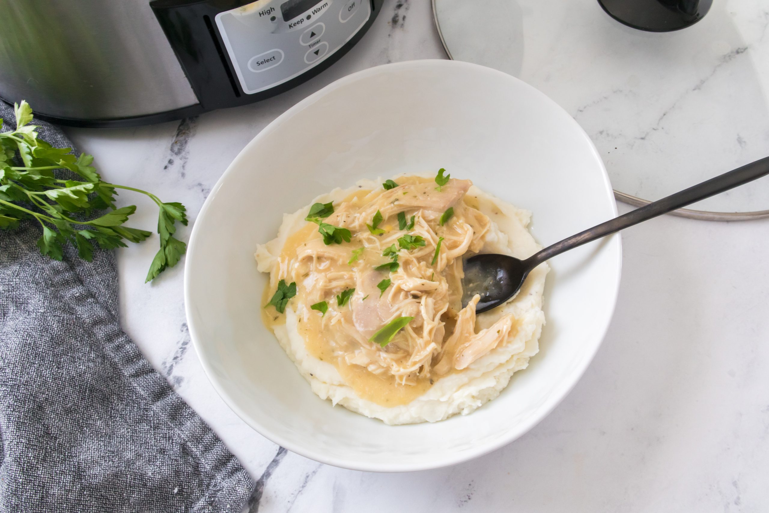 chicken and gravy in a crock pot recipe in a white bowl