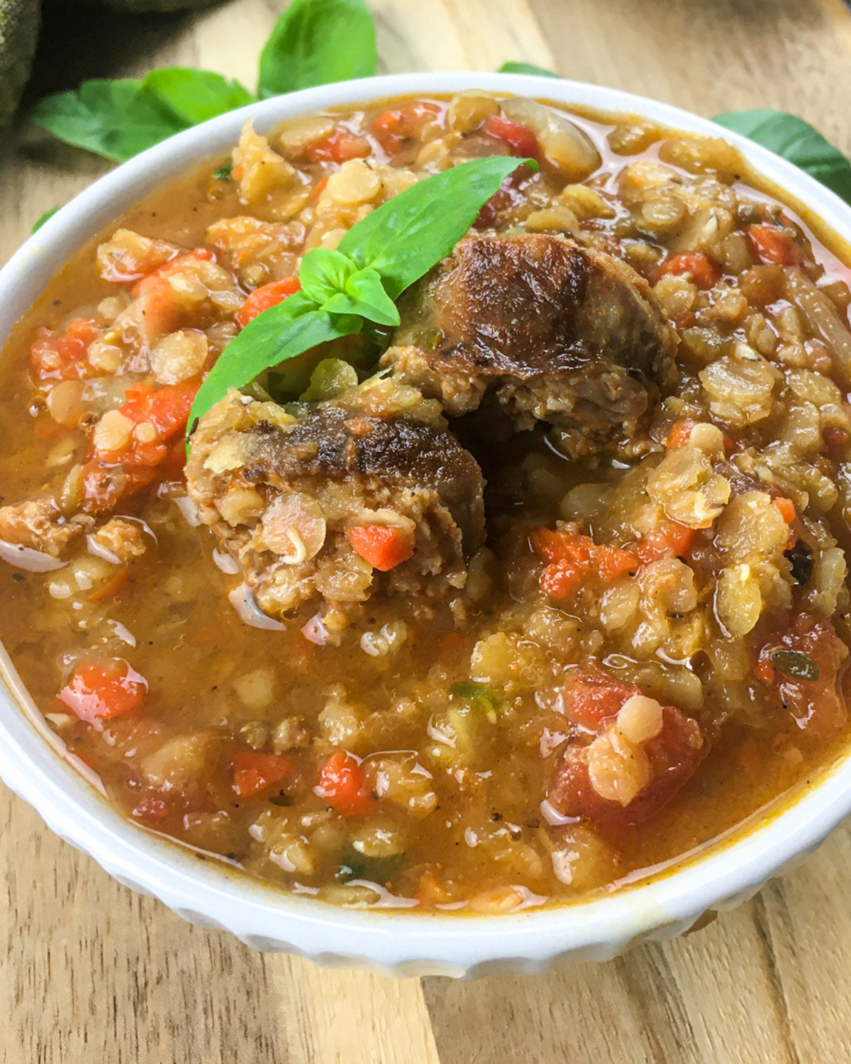 hearty spanish lentil soup with chorizo and tomatoes in bowl