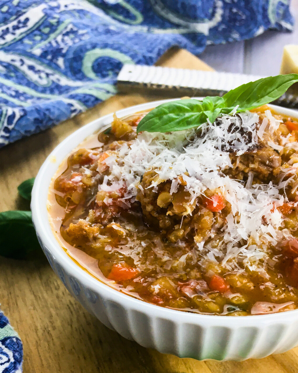 homemade chorizo lentil soup garnished with basil leaves