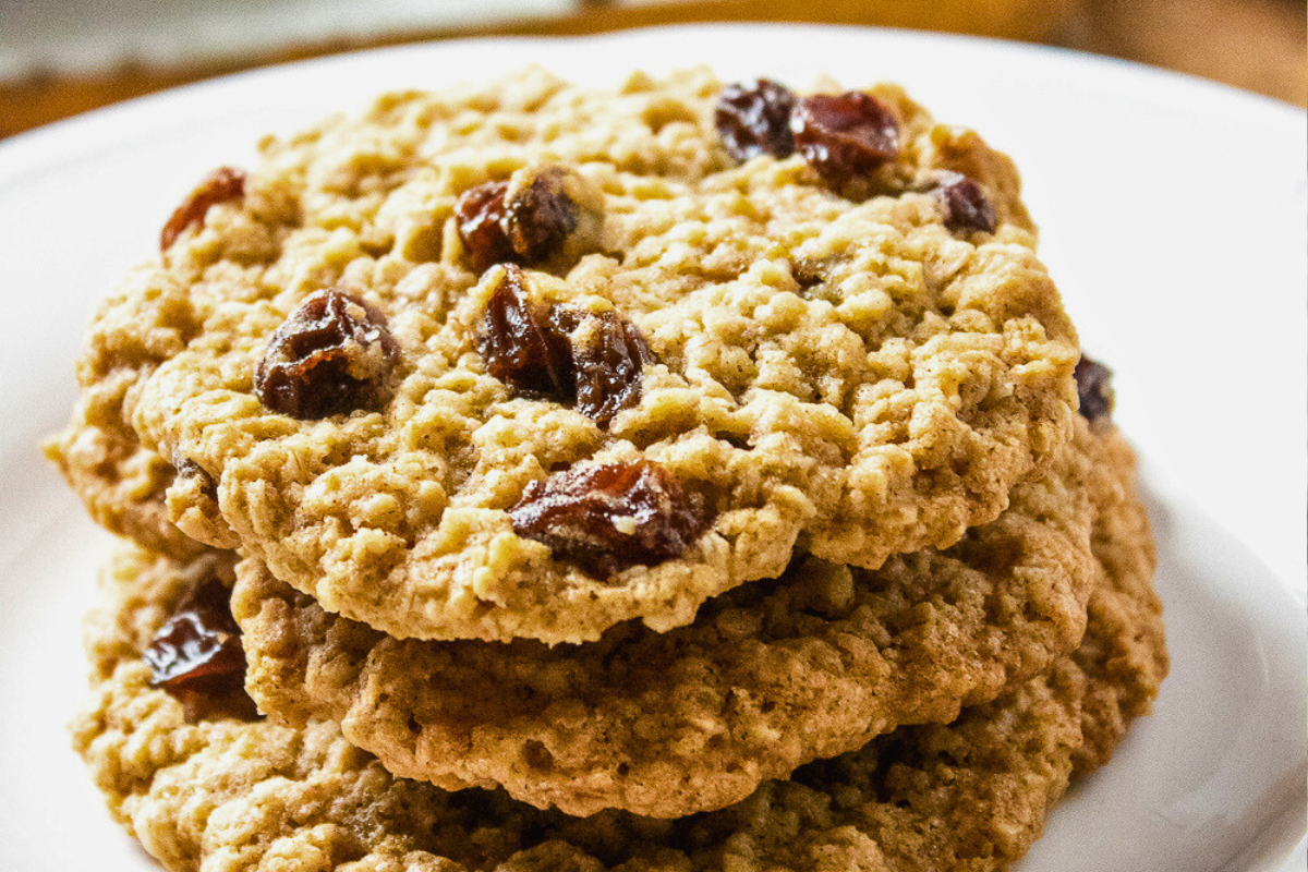 Stack of chewy oatmeal raisin cookies on cooling rack with visible plump raisins