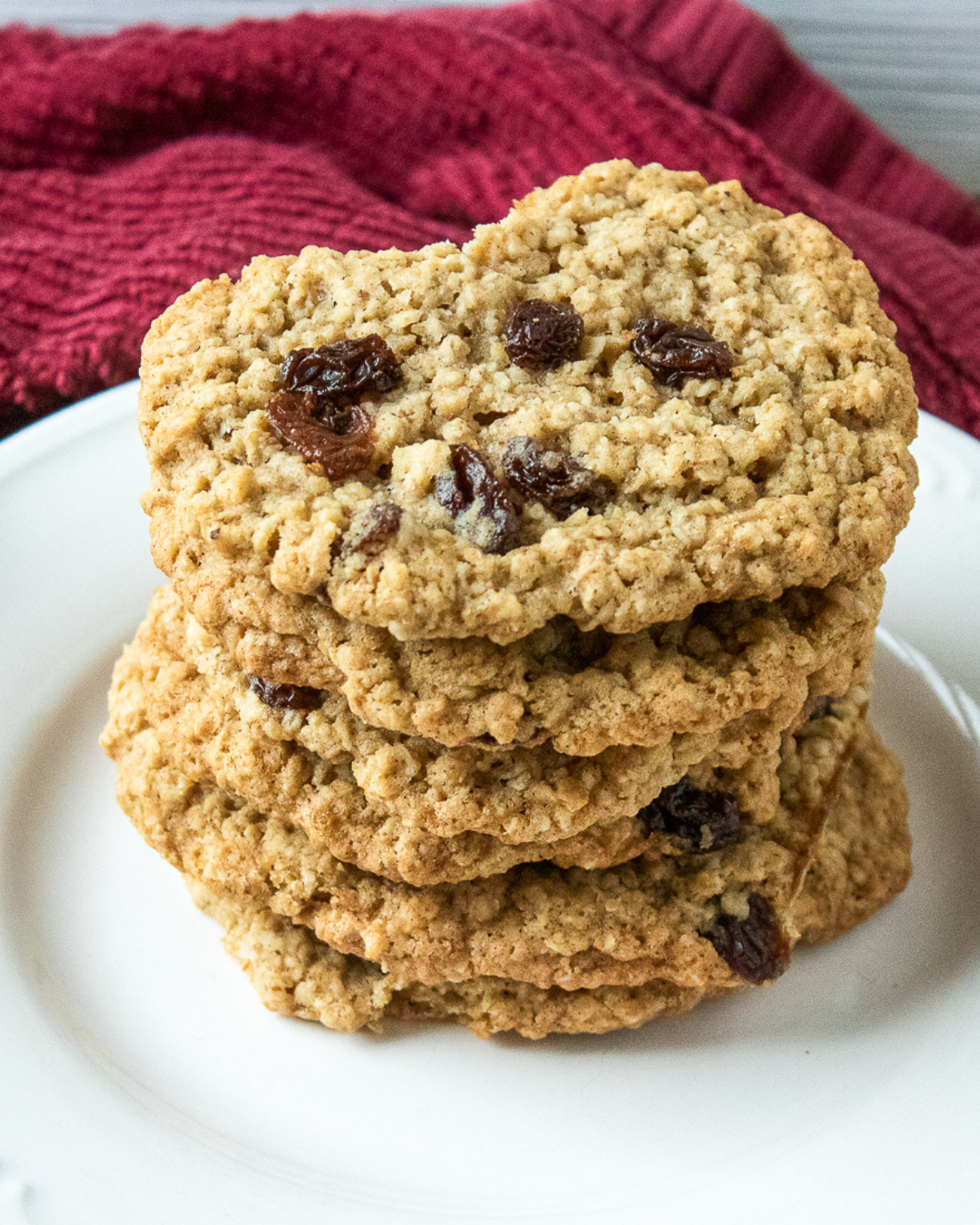 Soft and chewy oatmeal raisin cookies served on plate with cooling rack behind