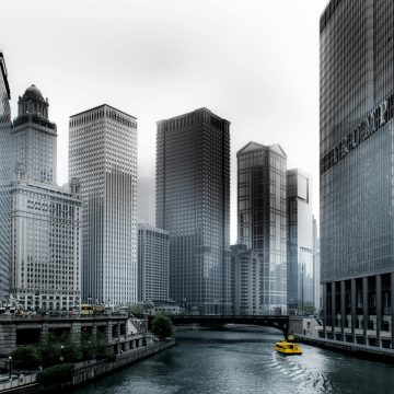 Stunning view of Chicago's skyscrapers along the river with a yellow water taxi.