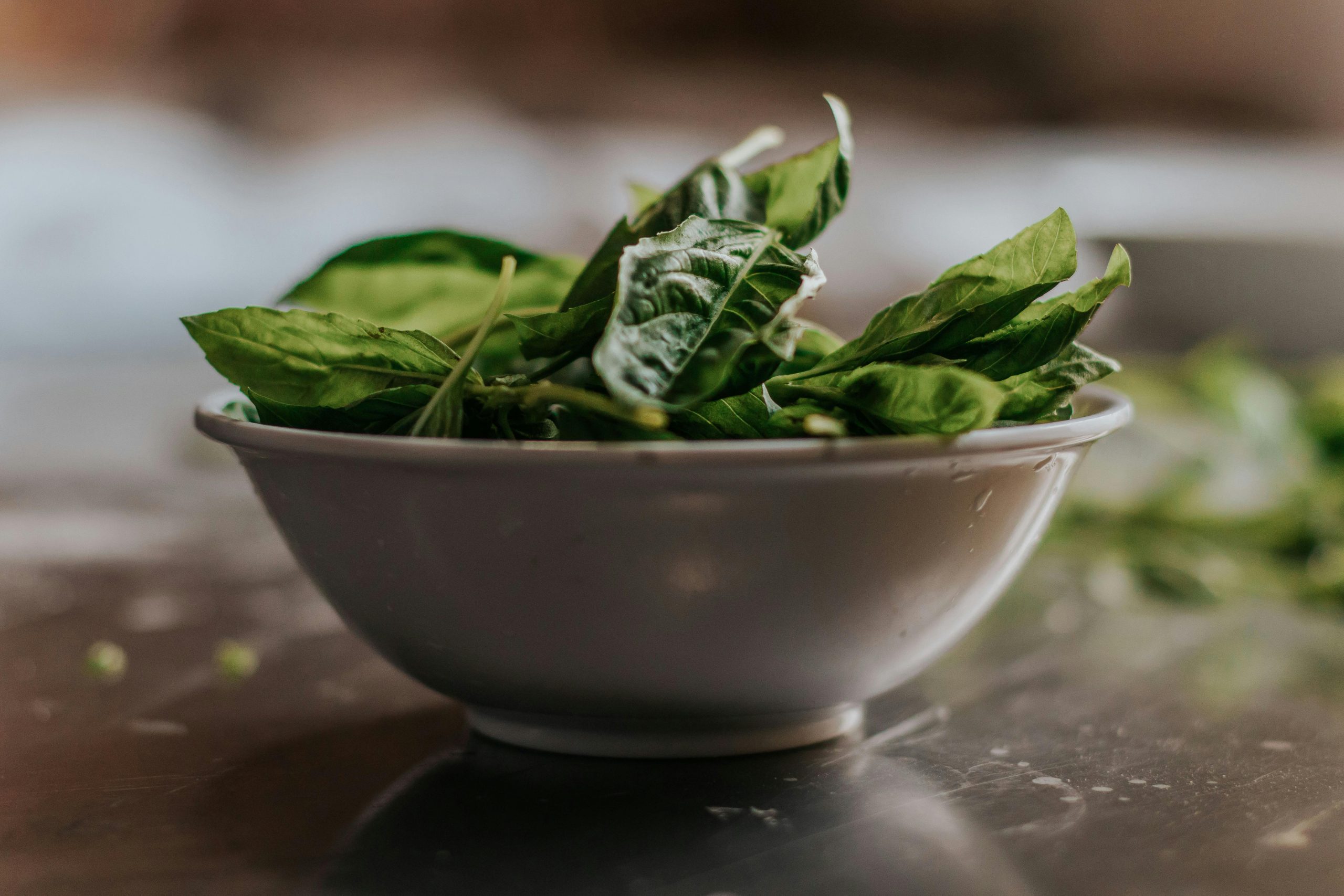Close-up of fresh spinach leaves in a ceramic bowl, perfect for healthy eating themes.