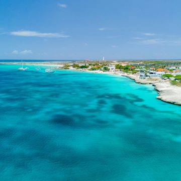A breathtaking aerial view of Aruba's coastline featuring turquoise waters and a clear blue sky.