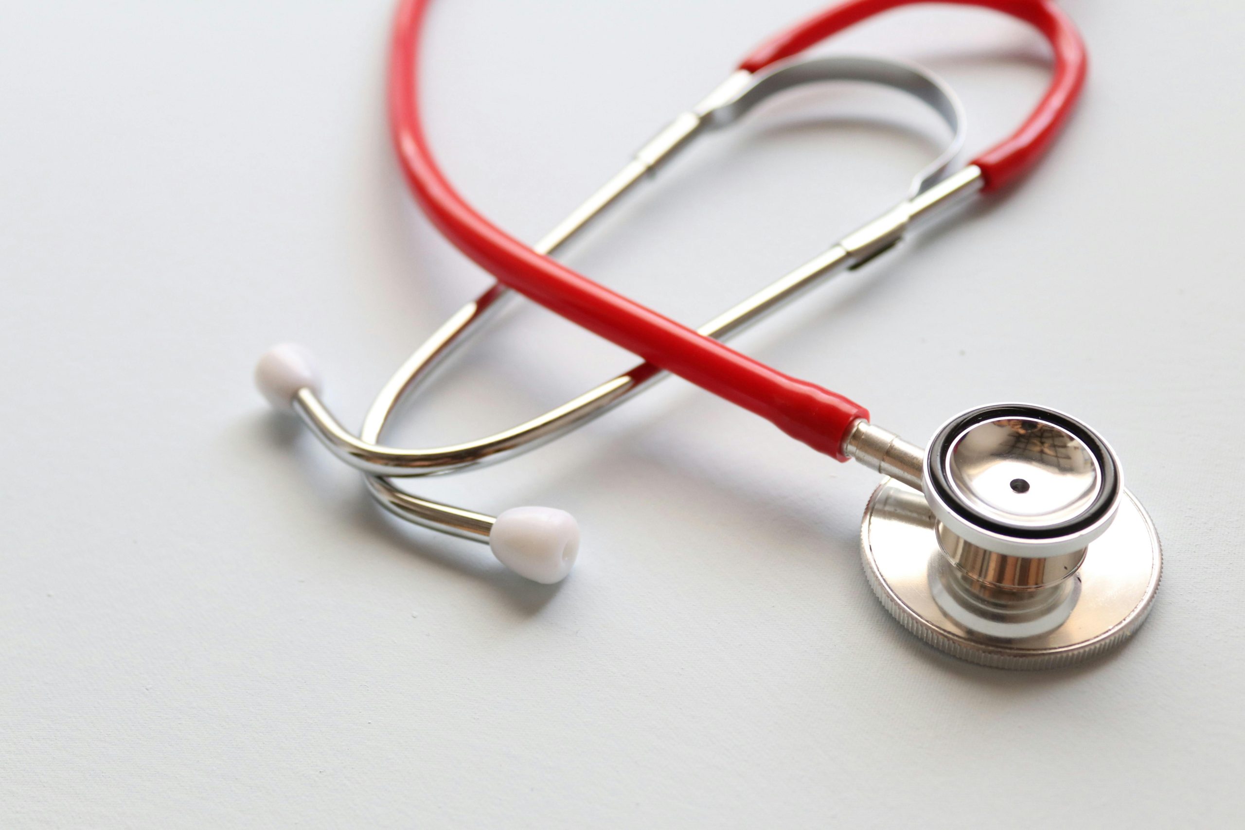 Close-up of a red stethoscope symbolizing medical care and healthcare diagnostics.