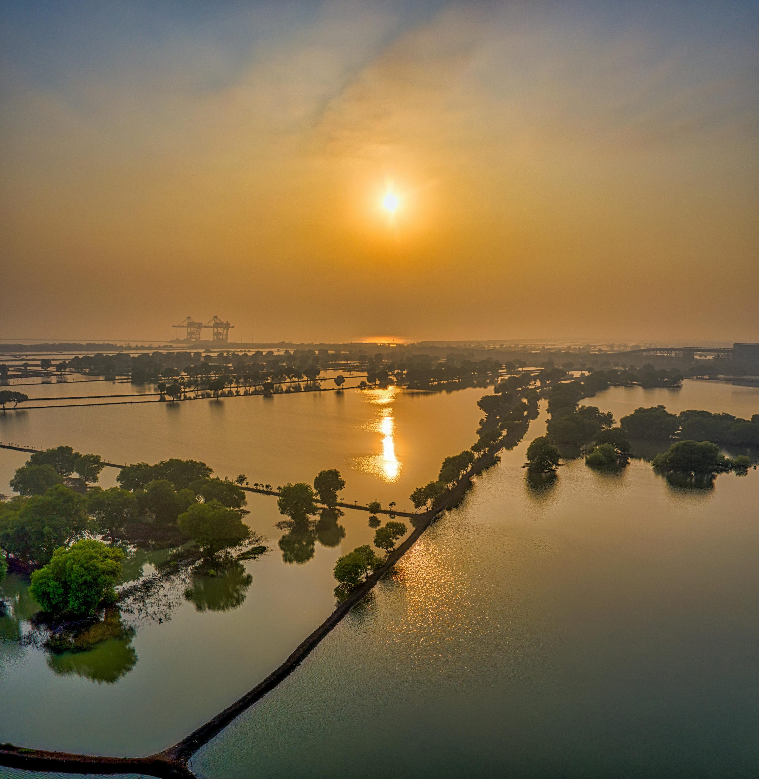 Breathtaking aerial panorama of a tranquil sunset over flooded fields in Banten, enhancing natural beauty and serenity.