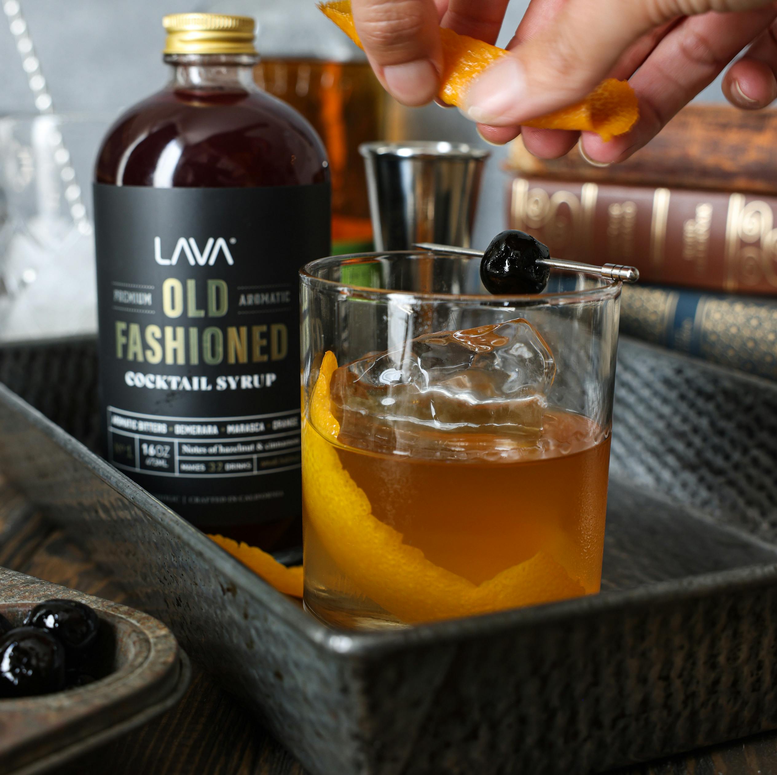 A classic Old Fashioned cocktail with orange peel and cocktail syrup, garnished elegantly for a refreshing experience.