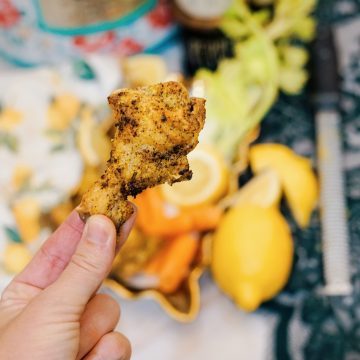 lemon pepper chicken wing in someone's hand