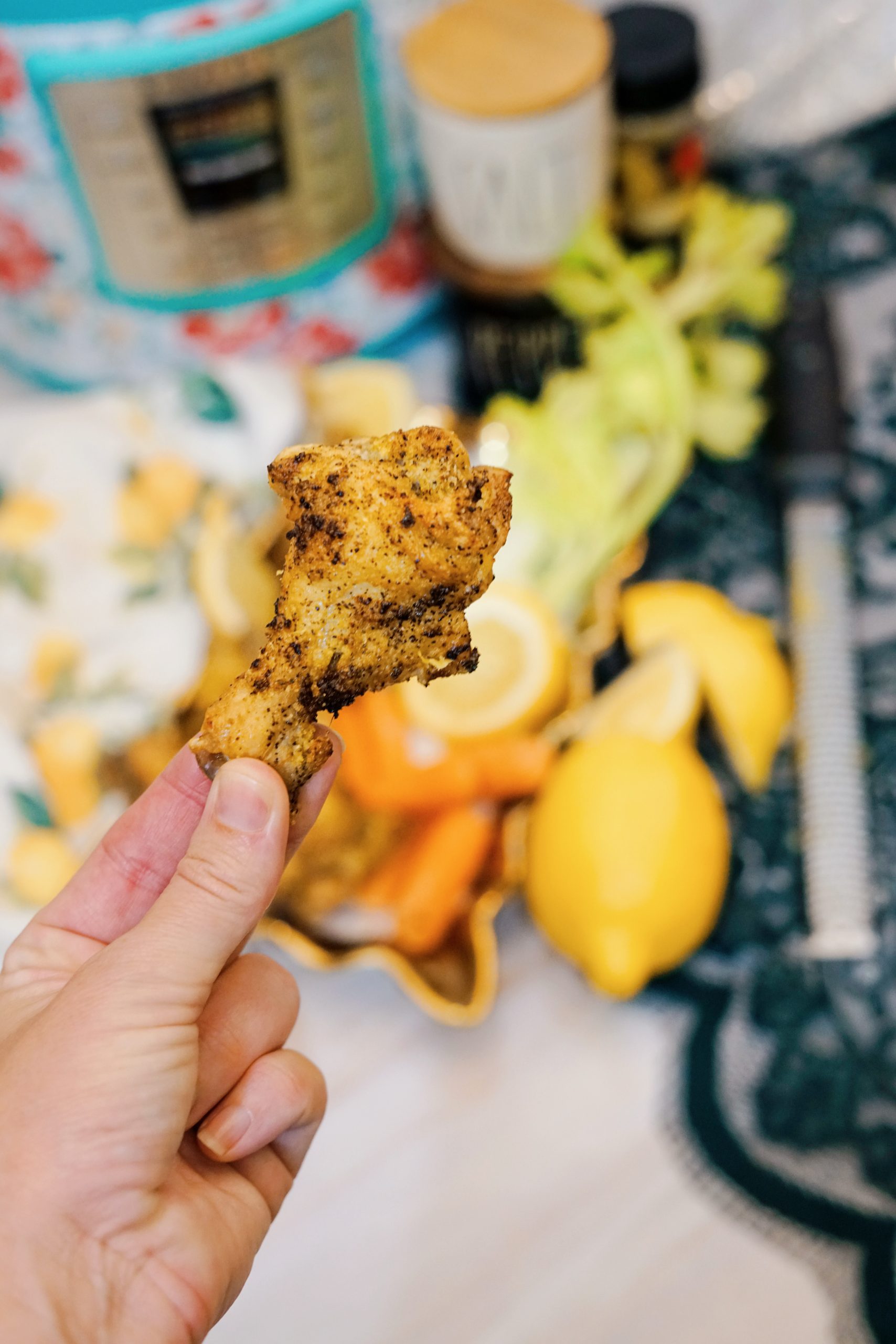 lemon pepper chicken wing in someone's hand