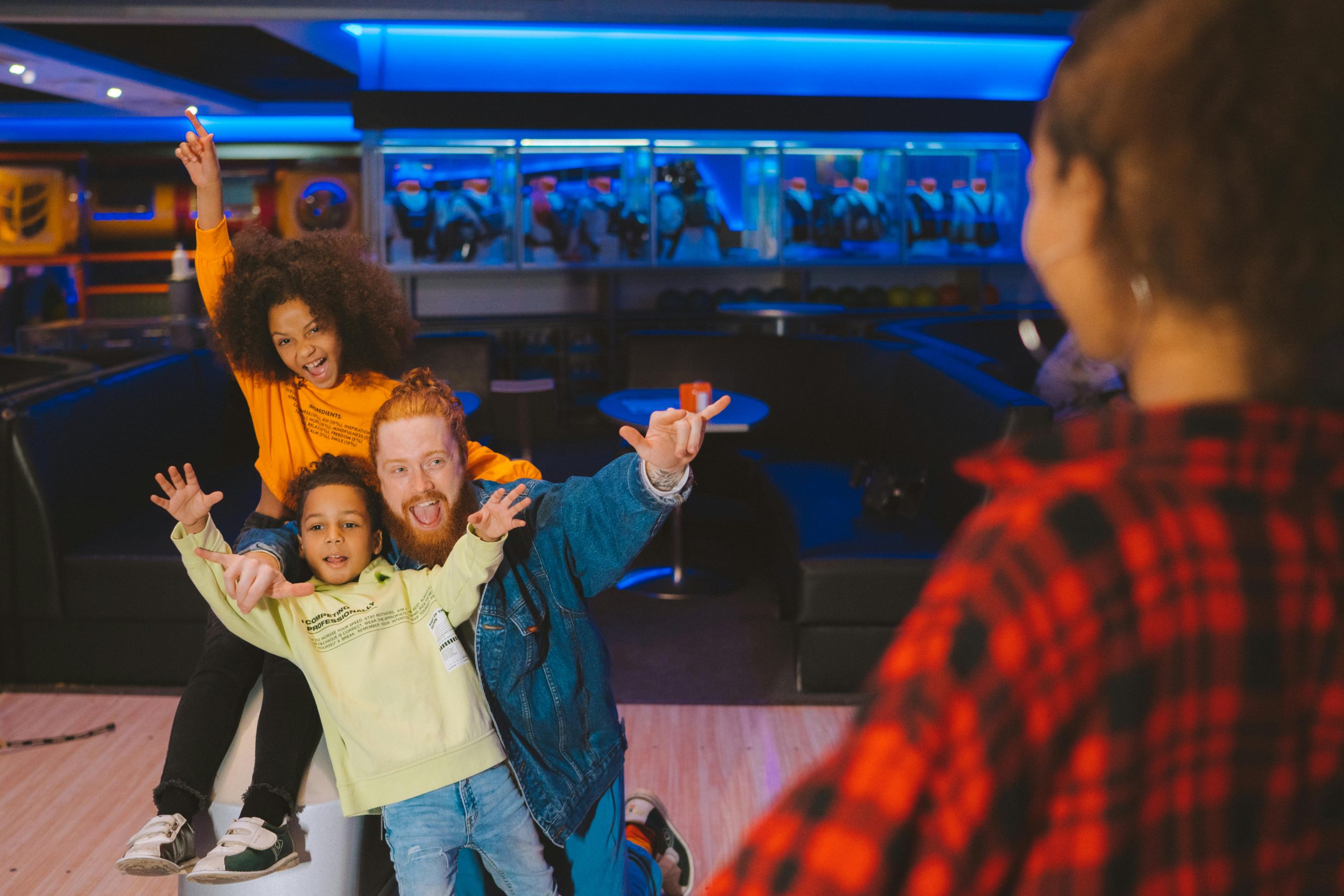 A happy family having fun and posing together at a bowling alley.